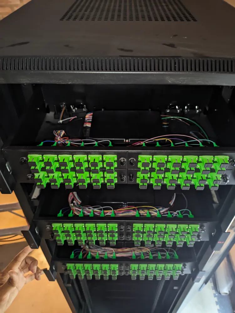 Bandejas de un distribuidor óptico de alta densidad con conectores SC/APC verdes y pigtails de colores