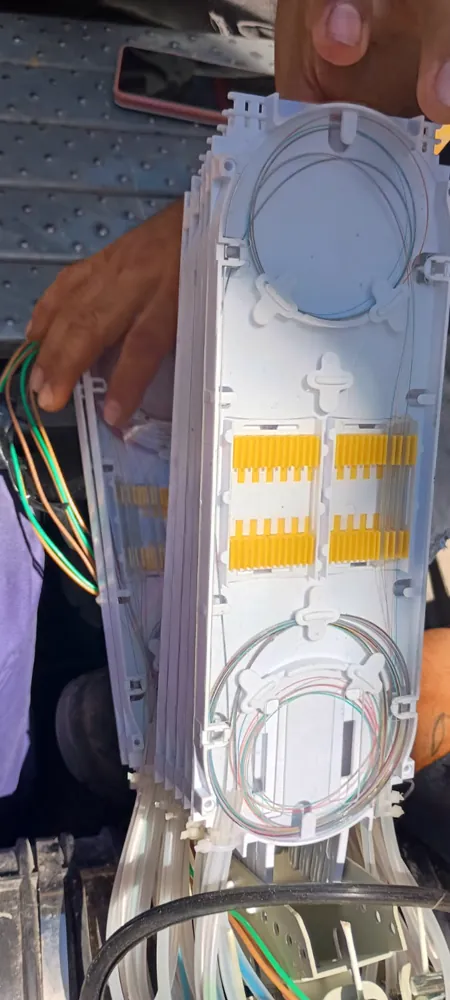 Manga de empalme abierta mostrando sus bandejas de fusión y los protectores de empalme
