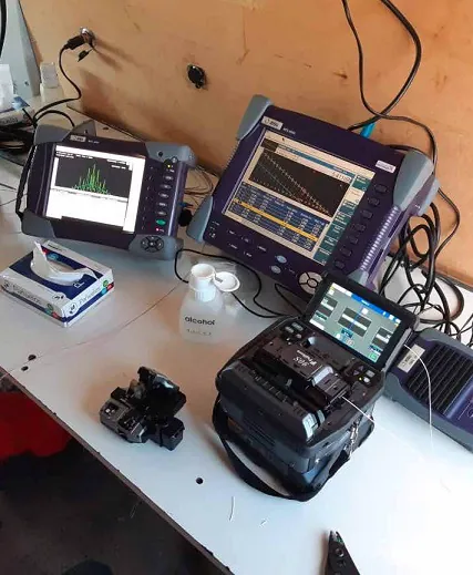 Puesto de trabajo con dos OTDR, fusionadora y cortadora de precisión durante la certificación de un enlace
